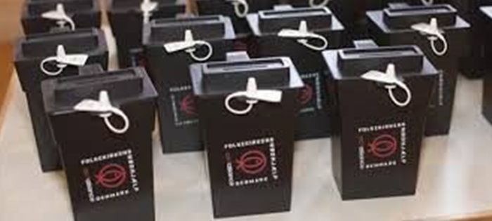 Mehrere schwarze Schachteln mit rotem Logo und weißer Schleife.